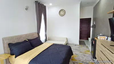 a bedroom with a bed and a clock on the wall at Studio Amani 2 Permatang Pauh in Permatang Pauh
