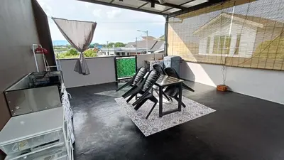 a balcony with chairs and a television on a roof at Studio Amani 2 Permatang Pauh in Permatang Pauh