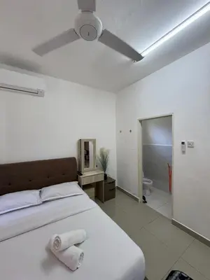 a bedroom with a bed and a ceiling fan at FHS Homestay Trong Taiping in Bukit Gantang