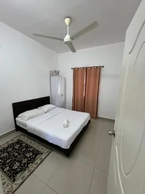 a bedroom with a bed and a ceiling fan at FHS Homestay Trong Taiping in Bukit Gantang