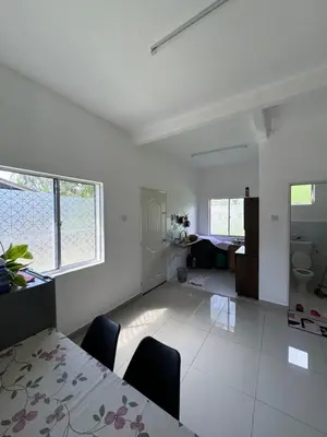 a white living room with a table and chairs at FHS Homestay Trong Taiping in Bukit Gantang