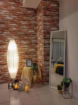 a room with a brick wall with a bed and a mirror at NEW! Spacious 3BR Luxury Stay at Sunrise Gurney GeorgeTown in George Town