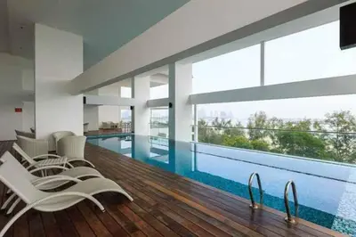 a house with a swimming pool with chairs and a swimming pool at NEW! Spacious 3BR Luxury Stay at Sunrise Gurney GeorgeTown in George Town