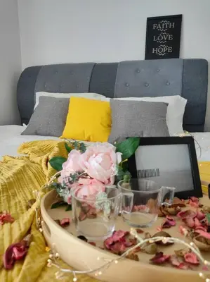 a tray with flowers and glasses on a bed at NEW! Spacious 3BR Luxury Stay at Sunrise Gurney GeorgeTown in George Town