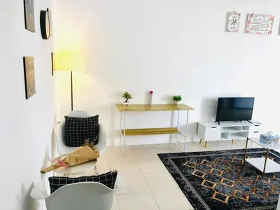 a white living room with a tv and a table at Syapins Cozy Haven Lunas Homestay Musslim Only in Lunas