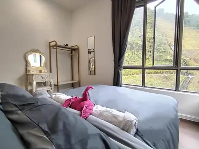 a stuffed animal laying on a couch in front of a window at Palas Horizon Home B-7-11 in Brinchang