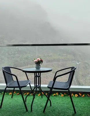 a table with two chairs and a vase of flowers at Palas Horizon Home B-7-11 in Brinchang