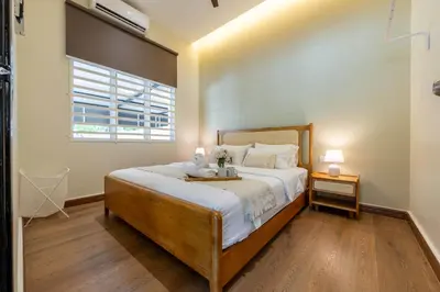 a bedroom with a large bed and a window at La Ferringhi Villa by BRB in Batu Ferringhi