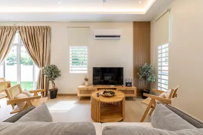 a living room with a couch and a tv at La Ferringhi Villa by BRB in Batu Ferringhi