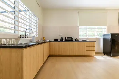 a kitchen with wooden cabinets and a stainless steel refrigerator at La Ferringhi Villa by BRB in Batu Ferringhi