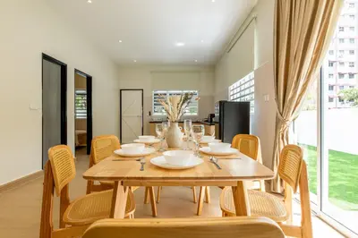 a dining room with a wooden table and chairs at La Ferringhi Villa by BRB in Batu Ferringhi