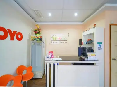 a kitchen with a counter and orange chairs in a room at Hotel O J Stay Guesthouse in Jelutong