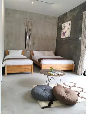 a bedroom with two beds and a table and pillows at Silvan Garden Cameron Highlands in Tanah Rata