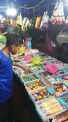 a young boy standing in front of a table of toys at Kak Chik Homestay Tasek Gelugor in Kampong Ayer Melintas Besar
