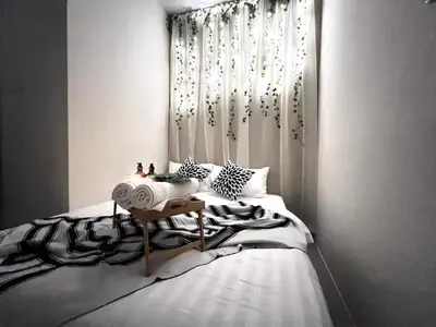 a bedroom with a bed with a table and a window at Stylish&Affordable Serenity Suite #2min KekLokSi in Ayer Itam