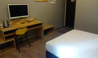 a bedroom with a bed and a desk with a computer at JQ Suria 18 Hotel in Ipoh