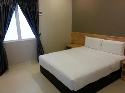 a bedroom with a white bed with a window at JQ Suria 18 Hotel in Ipoh