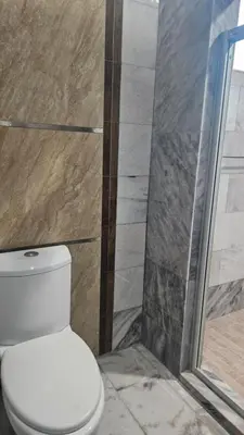 a bathroom with a toilet and a glass shower at Mount Lake Villa in Ipoh