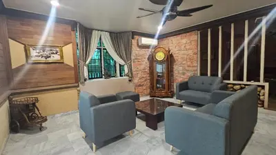 a living room with chairs and a table and a clock at Mount Lake Villa in Ipoh