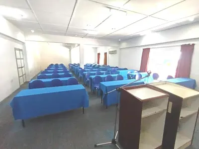 a room with blue chairs and a table and a podium at Collection O Analisa Beach Resort in Pangkor