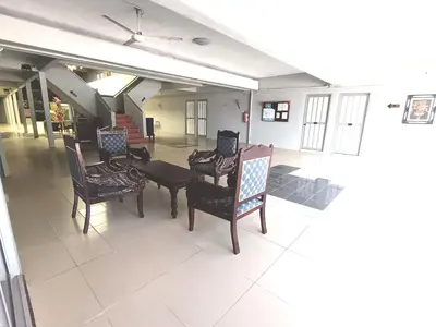 a room with chairs and a table in a building at Collection O Analisa Beach Resort in Pangkor