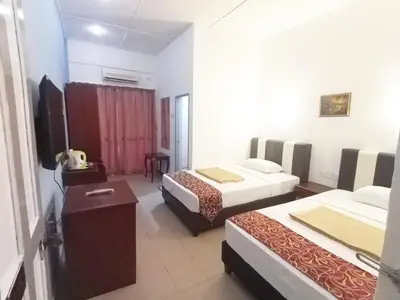 a hotel room with two beds and a television at Collection O Analisa Beach Resort in Pangkor