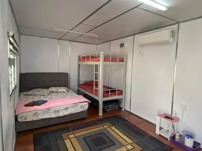 a bedroom with a bed and a shelf in a room at YN cabin in Tanjung Karang