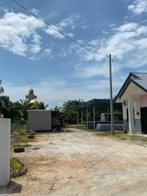 a dirt yard with a building and a house at YN cabin in Tanjung Karang