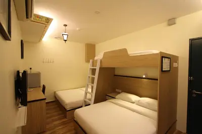 a bedroom with two bunk beds and a ladder at Shamrock Guest House II in Ipoh