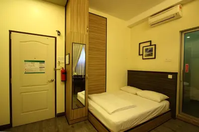 a small bedroom with a bed and a mirror at Shamrock Guest House II in Ipoh