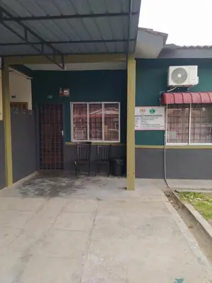 a building with two chairs in front of it at Atbas Homestay No 1 in Seri Iskandar