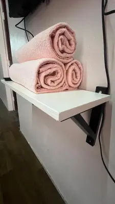 a pink towel sitting on a shelf in a bathroom at Atbas Homestay No 1 in Seri Iskandar
