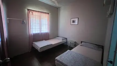 a small room with two beds and a window at Atbas Homestay No 1 in Seri Iskandar
