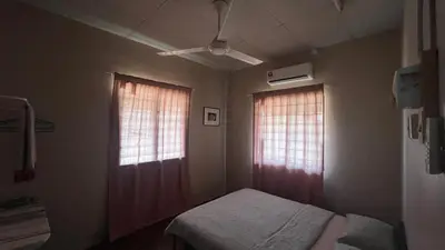 a small bedroom with two windows and a bed at Atbas Homestay No 1 in Seri Iskandar