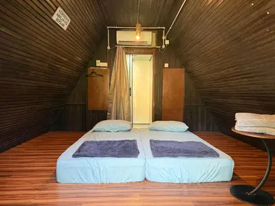 a bedroom with two beds in a dark room at Chalet Kuala Woh Resort in Tapah