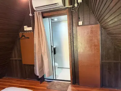 a bathroom with a glass shower in a attic at Chalet Kuala Woh Resort in Tapah