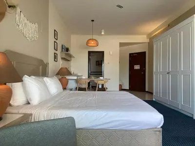 a bedroom with a large white bed and a table at Rainbow Paradise with Beach in Tanjung Bungah in Tanjung Bungah