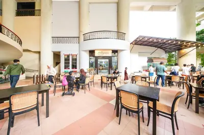 a group of people sitting at tables in a restaurant at Rainbow Paradise with Beach in Tanjung Bungah in Tanjung Bungah