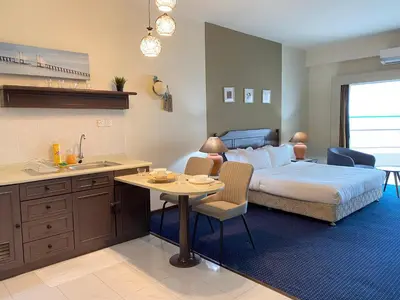 a bedroom with a bed and a kitchen with a table at Rainbow Paradise with Beach in Tanjung Bungah in Tanjung Bungah