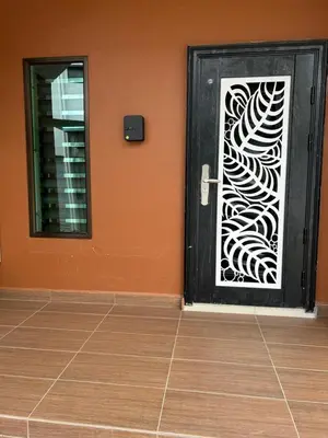 a black door with a white stencil on a orange wall at Orkid Apartment 2 in Cameron Highlands