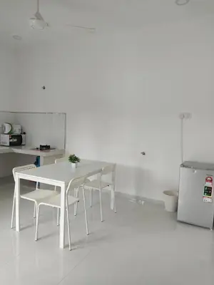 a white dining room with a white table and chairs at Homestay Bajet Cikgu Amin in Bagan Serai