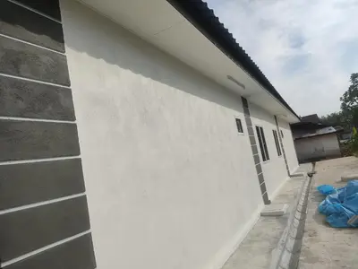 a white wall next to a building at Homestay Bajet Cikgu Amin in Bagan Serai