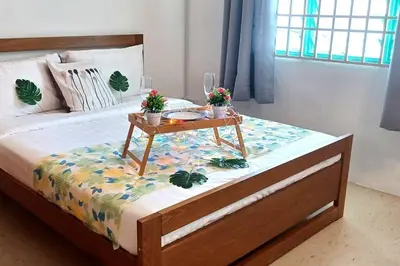 a bed with a table with plants on it at Pepper Hillside Village Home in Tanjung Bungah