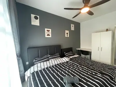 a bedroom with a black and white bed and a ceiling fan at Ipoh Town The Anderson Residence in Ipoh