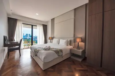 a bedroom with a bed and a desk and a window at The Landmark Seaview Suite in Tanjong Tokong
