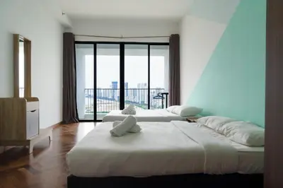 two beds in a room with a large window at The Landmark Seaview Suite in Tanjong Tokong