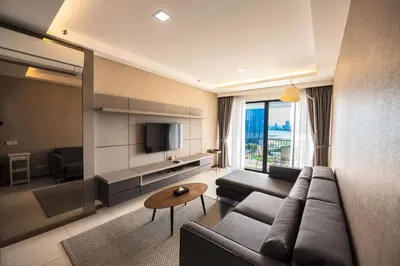 a living room with a couch and a tv at The Landmark Seaview Suite in Tanjong Tokong