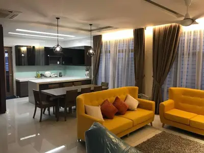 a living room with a yellow couch and a table at Batu Ferringhi Home Near Beach in Penang in Batu Ferringhi