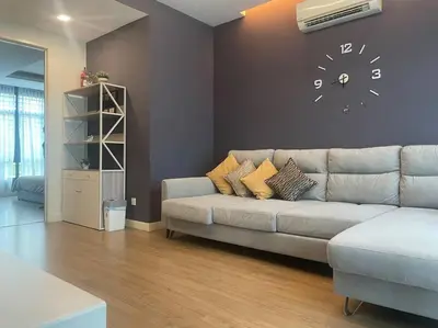 a living room with a couch and a clock on the wall at Batu Ferringhi Home Near Beach in Penang in Batu Ferringhi