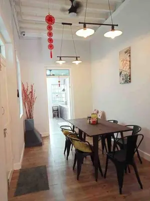a dining room with a wooden table and chairs at Modern Victorian Homestay in George Town